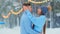 Young man hugs girlfriend in blue sweater on open ice rink