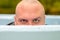 Young man hunkering down in an outdoor tub or pool