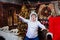 A young man in an Indian roach feather headdress and funny glasses poses and makes faces on a Christmas background