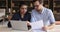 Young man with indian woman engaged in paperwork using laptop