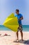 Young man install in sand solar umbrella on a beach near ocean