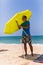 Young man install in sand solar umbrella on a beach near ocean