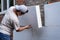 A young man insulates the walls of an apartment building