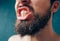 Young man isolated over background. Cut view and close up of bearded male person show teeth. Healthy good oral and
