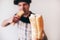 Young man isolated over defocused blurred background. Showing one piece of it on camera. Hungry cook biting another