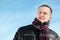 Young man in jacket stands by winter day