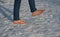 Young man in jeans walks barefoot in the snow. it bleeds the blood in the legs a lot and it stings slightly. there is no risk of f