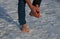 Young man in jeans walks barefoot in the snow. it bleeds the blood in the legs a lot and it stings slightly. there is no risk of f