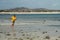 Young man jogging on the beach in summer. Indonesian teenager in shorts and a yellow T-shirt running on the beach