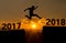 A young man jump between 2017 and 2018 years over the sun