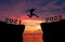 A young man jump between 2021 and 2022 years over the twilight sky and through on the gap of hill silhouette evening colorful sky