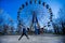 Young man jump with Ferris wheel on background in spring