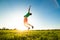 Young man jumping on meadow with dandelions