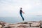 Young man jumping upwards portraying a flight against the background of the sea and sky. The concept of freedom. Life