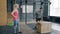 Young man jumping on wooden box during crossfit training while female coach watching