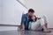 Young man kissing woman forehead sitting on the floor in white kitchen, relationship, family, love, housewarming
