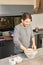 Young man in the kitchen kneading while dough