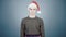 Young man in knitted sweater and santa hat puts on carnival costume details Christmas preparation