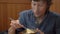 Young man in a korean restaurant eats traditional korean noodle Udon