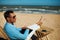 Young man with Laptop computer during tropical beach vacation