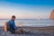 Young man with laptop working on the beach. Freedom, remote work, freelancer, technology, internet, travel and vacation concepts