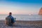 Young man with laptop working on the beach. Freedom, remote work, freelancer, technology, internet, travel and vacation concepts