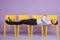 Young man laying down on yellow chairs looking in camera