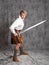 A young man in a leather kilt and a white lace-up blouse. combat stance.