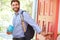 Young Man Leaving Home For Work With Packed Lunch