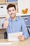 Young man with letter holds thumbs up