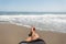 Young man lies on the sand by the ocean and sunbathes. Guy relaxes on the sea coast on a sunny hot summer day. Men`s legs