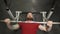 Young man lifting the barbell in the gym portrait. Steadycam follow shot of male athlete with brutal beard