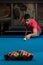 Young Man Lining To Hit Ball On Pool Table