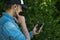 Young man listening to music with wireless earbuds and his smartphone. Technological concept