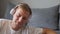 A young man listens to music with headphones at home