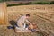 Young man and little boy making picnic on hay field