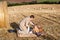 Young man and little boy making picnic on hay field