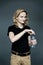 A young man with long blond hair  drinks clean water from a bottle