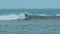 Young man with long hair rides the ocean wave at the Mauritius surf spot