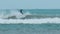 Young man with long hair rides the ocean wave at the Mauritius surf spot