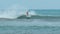 Young man with long hair rides the ocean wave at the Mauritius surf spot