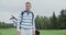 Young man looking at the camera and smiling while standing on a golf course