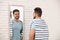 Young man looking at himself in large mirror