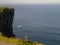 Young man looking at his smart phone screen at bright sunlight, Cliff of Moher, Ireland, Travel concept