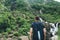 Young man looking at mountain stream in the forest admires nature.