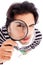 Young man looking up with a magnifying glass