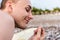 A young man looks at a small pebble in his hand