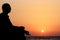 Young man in lotus position & meditating on beach