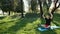 A Young Man In A Lotus Position Sitting On The Green Grass In The Park. The Concept Of Calm And Meditation. Hands In The