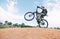 A young man makes tricks on a mountain bike. A cyclist jumps on a bike